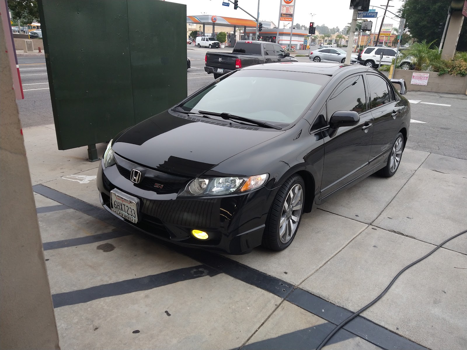 Black Honda sedan finished and parked outside the Sylmar detailing bay